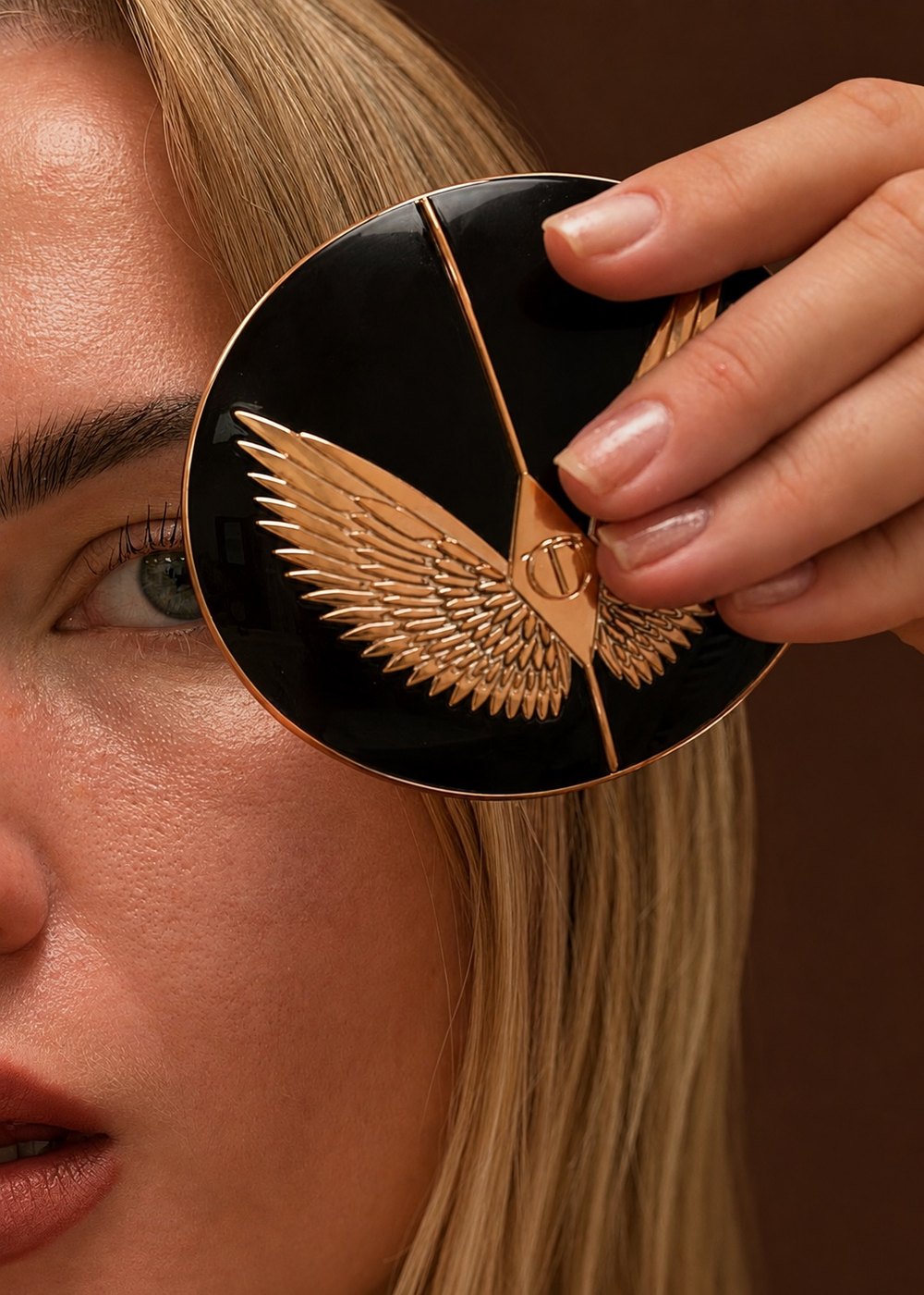Julia holding a Charlotte Tilbury compact over one eye